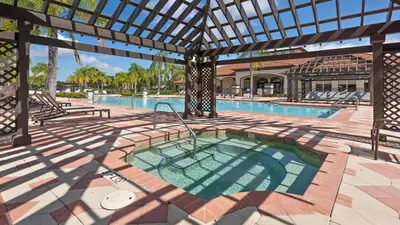 an outdoor swimming pool with a large pergola at 3-Bedroom Villa in Bella Vida Resort, Close2Disney in Kissimmee