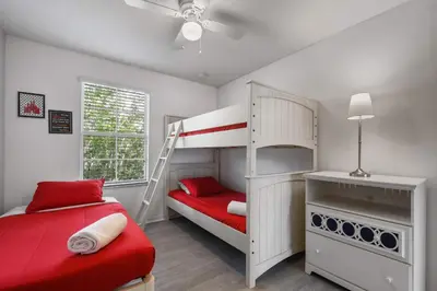 a bedroom with a bunk bed and a red bed at 3-Bedroom Villa in Bella Vida Resort, Close2Disney in Kissimmee