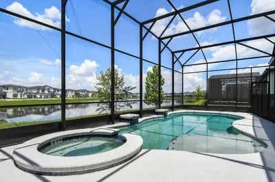 a large swimming pool in a building with a large window at Luxurious 15BR Villa with Lake View & Game/Theater in Orlando