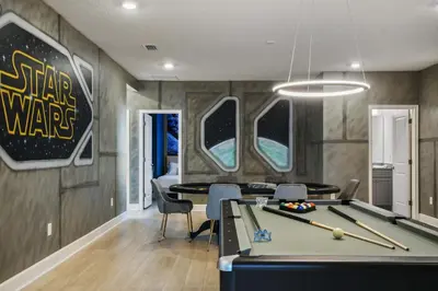 a room with a pool table and a star wars sign at Luxurious 15BR Villa with Lake View & Game/Theater in Orlando