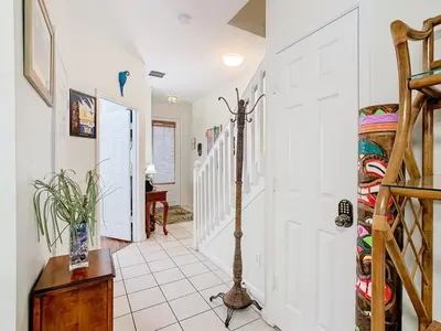 a hallway with white walls and a white staircase at Adventureland Oasis - Resort Near Disney in Kissimmee