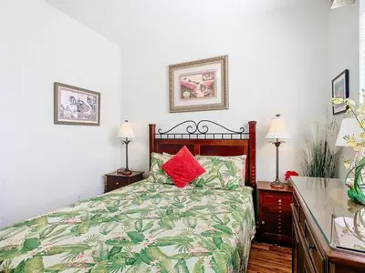 a bedroom with a bed with red pillows on it at Adventureland Oasis - Resort Near Disney in Kissimmee