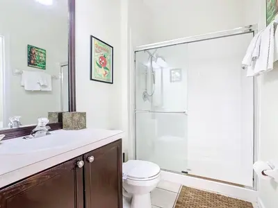 a bathroom with a toilet and a sink and a shower at Adventureland Oasis - Resort Near Disney in Kissimmee