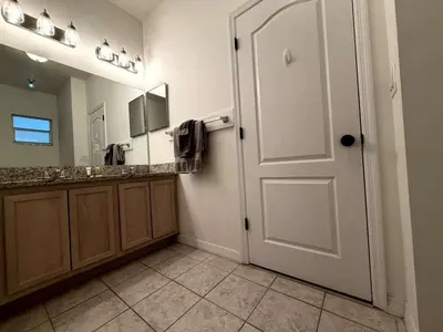 a bathroom with a white door and a mirror at Fun Disney Oasis Pool House with Spa Game Room Kids Playground and 10 min from Disney in Kissimmee