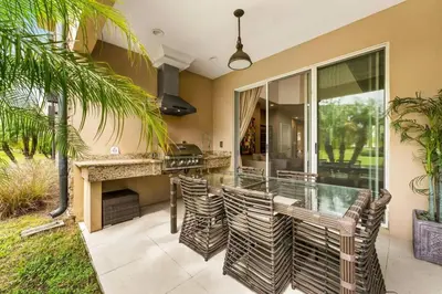 a patio with a bar with chairs and a fireplace at Casa 4Q c/ Varandas c/ Churrasqueira – Perto Disn in Orlando