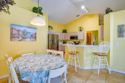 a kitchen and dining room with a table and chairs at 9 Mi to Walt Disney World Family Home with Pool! in Orlando