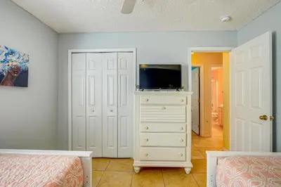 a bedroom with a tv on top of a dresser at 9 Mi to Walt Disney World Family Home with Pool! in Orlando