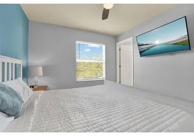 a bedroom with a bed and a tv on the wall at 3157 YL - Encantada Serenity Retreat Elegant Villa Close to Disney in Kissimmee