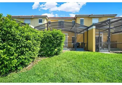 a building with a green hedge in front of it at 3157 YL - Encantada Serenity Retreat Elegant Villa Close to Disney in Kissimmee
