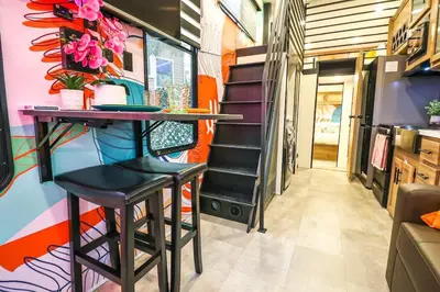 a dining room with a table and stools in a trailer at FunTropicalTinyGemUCF in Orlando