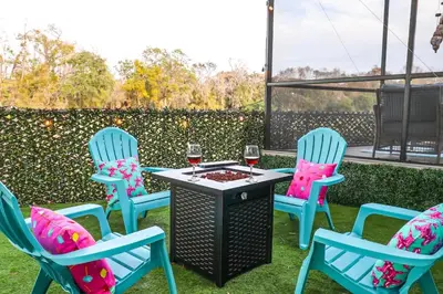 three chairs and a table with two glasses of wine at FunTropicalTinyGemUCF in Orlando
