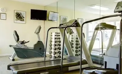 a gym with a treadmill and a mirror at 3-BR Condo near Disney & Universal in Kissimmee