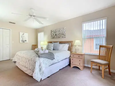 a bedroom with a bed and a chair and a window at Family Getaway: 4BR Townhome by Old Town in Orlando