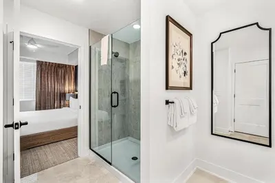 a white bathroom with a shower and a glass door at Villatel Orlando Resort, Apartments by Marriott Bonvoy in Orlando