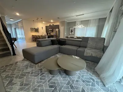 a living room with a couch and a table at 5BR c/Piscina Privada | Luxo em Storey Lake in Kissimmee