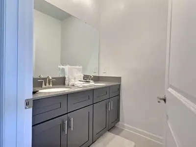 a bathroom with a sink and a large mirror at 5BR c/Piscina Privada | Luxo em Storey Lake in Kissimmee
