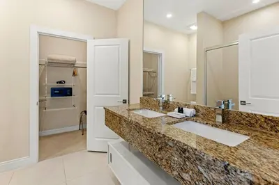 a bathroom with two sinks and a large mirror at 7639- Encantadora Casa com 3 Suítes no Magic Village Yards, Perto da Disney e da Rota 192 in Orlando