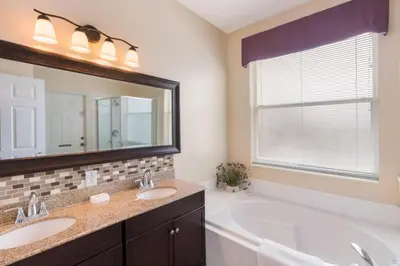 a bathroom with two sinks and a large mirror at Aruba Palms Villa Near Disney & Attractions in Kissimmee