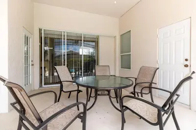 a dining room with a glass table and chairs at Aruba Palms Villa Near Disney & Attractions in Kissimmee
