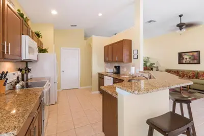 a large kitchen with a sink and a counter at Aruba Palms Villa Near Disney & Attractions in Kissimmee