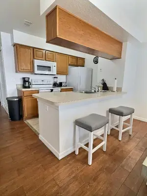 a kitchen with a counter and two stools at Apartamento 3 Quartos a Minutos da Disney in Kissimmee