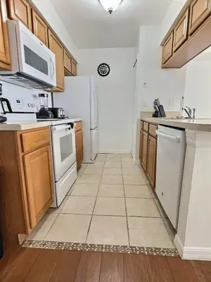 a kitchen with white appliances and wooden cabinets at Apartamento 3 Quartos a Minutos da Disney in Kissimmee