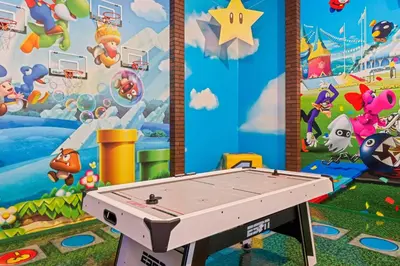 a ping pong table in front of a mural at The Luxurious Bear's Den Estate-TB009 in Orlando