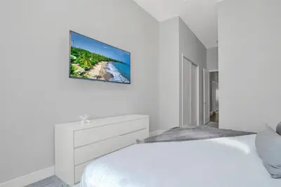 a white bedroom with a bed and a tv on the wall at The Luxurious Bear's Den Estate-TB009 in Orlando