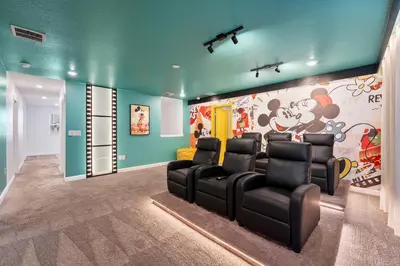 a room with black chairs and a wall with a mural at 2858 Storey Lake brand new 19guests pool game room in Kissimmee