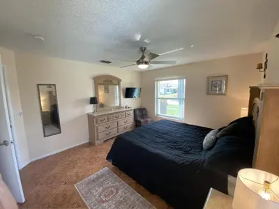 a bedroom with a bed and a dresser and a mirror at Beautiful Indian Ridge Home - Close to Disney in Orlando