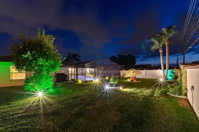 a house with lights in the yard at night at Beautiful Indian Ridge Home - Close to Disney in Orlando