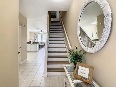 a hallway with a round mirror and a staircase at Celtic Palms: Private Pool & Near Disney Magic in Kissimmee