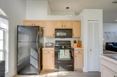 a kitchen with a stainless steel refrigerator and wooden cabinets at 6 Mi to Disney World Home with Large Yard! in Orlando
