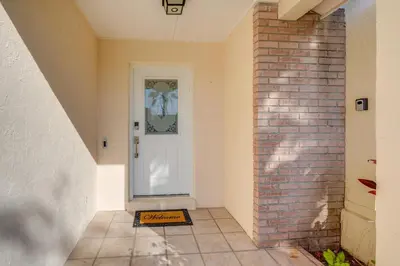 a hallway with a white door and a brick wall at 6 Mi to Disney World Home with Large Yard! in Orlando
