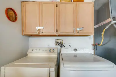 a kitchen with a washing machine and cabinets at 6 Mi to Disney World Home with Large Yard! in Orlando