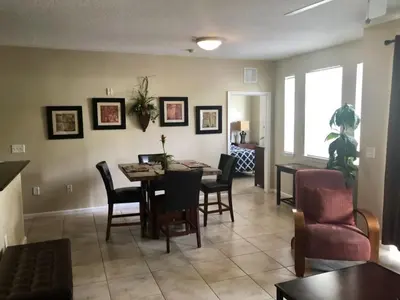 a living room with a dining room table and chairs at Cane Island Resort 2BR Condo, Close to Attractions in Kissimmee