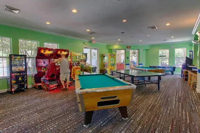 a boy playing a game in a game room with billards at Best deal on Windsor Palms South facing pool in Kissimmee