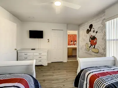 a bedroom with two beds and a wall with a mickey mouse mural at Old Town and Food trucks around the corner in Orlando
