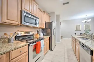 a kitchen with stainless steel appliances and wooden cabinets at Great deal townhome on Paradise Palms in Kissimmee