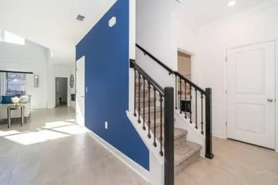 a staircase in a house with a blue wall at Serene Rhyme Escape in Kissimmee