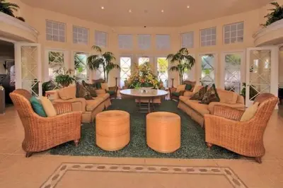 a large living room with wicker chairs and a table at Caribbean Breeze: Pool Home 3 Miles to Disney in Kissimmee