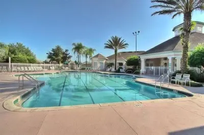 a large swimming pool in a resort with palm trees at Caribbean Breeze: Pool Home 3 Miles to Disney in Kissimmee
