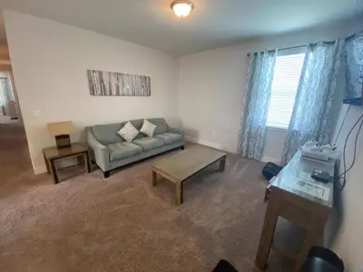 a living room with a couch and a table at Elegant Family Home | Pool, Spa & Themed Rooms in Orlando