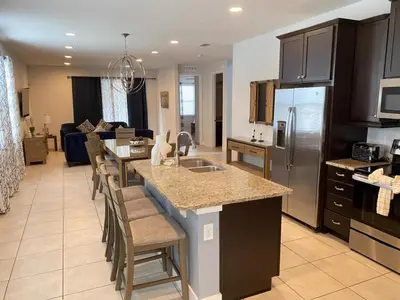a kitchen with a large island in a living room at Elegant Family Home | Pool, Spa & Themed Rooms in Orlando