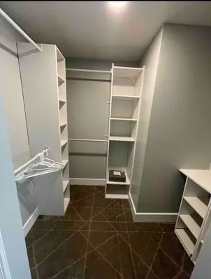 a walk in closet with white shelves and tile floors at Agradable casa parqueos gratis in Orlando