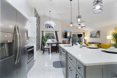 a kitchen with a refrigerator and a dining room at Four Seasons Vacation, heated Pool, 3mile 2 Disney in Kissimmee