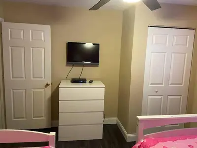 a bedroom with a bed and a tv on the wall at 4 Bedroom 3 Bathroom Villas At SevenDwarfs 20-102 in Kissimmee