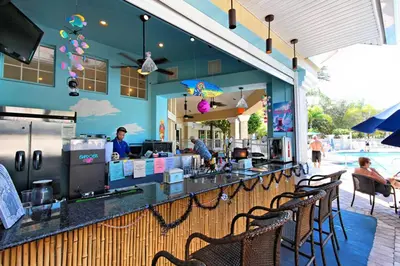 a restaurant with a bar with chairs and a pool at Family Villa Near Disney with Private Pool in Kissimmee