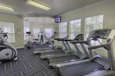 a gym with treadmills and ellipticals in a room at Family Villa Near Disney with Private Pool in Kissimmee