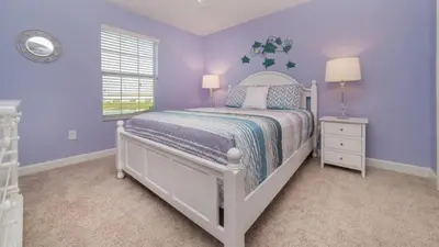 a purple bedroom with a white bed and a window at Gatsby Escape: Private Pool Near Disney & Resorts in Kissimmee